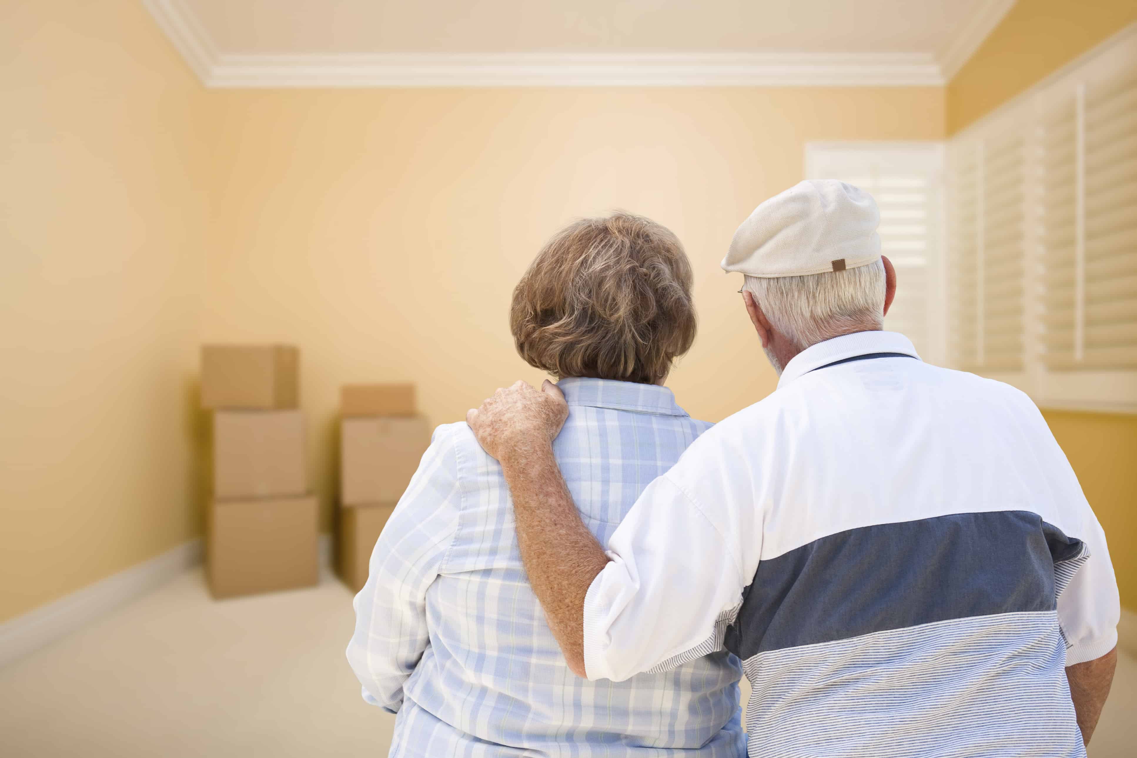 elderly couple looking at room with boxes