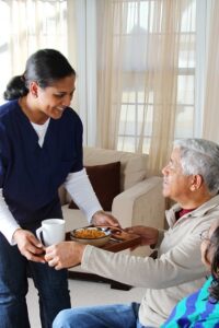 caregiver providing patient tray of food